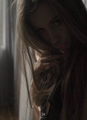 Молодая красотка в тёмной спальне